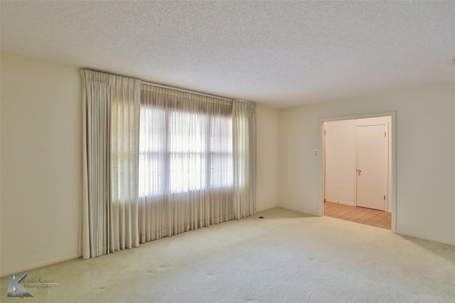 carpeted spare room with a textured ceiling