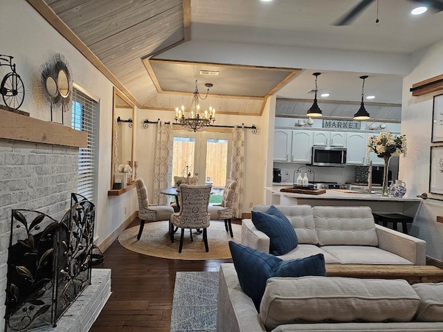 living room with lofted ceiling, dark hardwood / wood-style floors, ceiling fan with notable chandelier, and a wealth of natural light