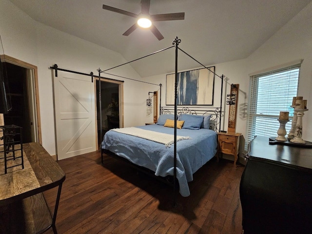 bedroom featuring ceiling fan, dark hardwood / wood-style flooring, a barn door, and lofted ceiling