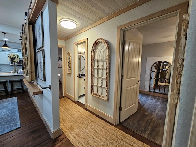 hall featuring ornamental molding, a barn door, and wood-type flooring