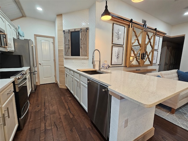 kitchen with lofted ceiling, a barn door, dark hardwood / wood-style flooring, sink, and range with electric cooktop