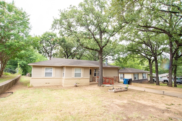 single story home featuring a front lawn and a wooden deck