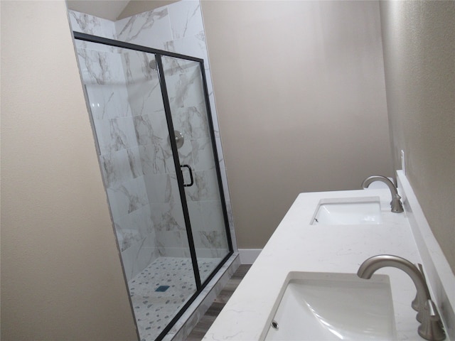 bathroom with double sink vanity, walk in shower, and hardwood / wood-style floors