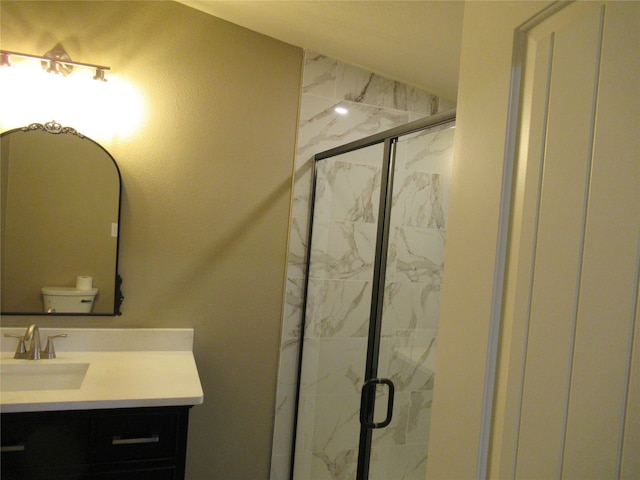 bathroom featuring toilet, vanity, and an enclosed shower