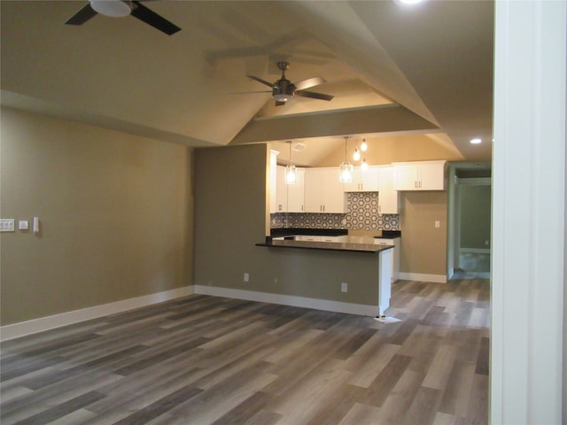 kitchen featuring tasteful backsplash, hanging light fixtures, white cabinetry, ceiling fan, and kitchen peninsula