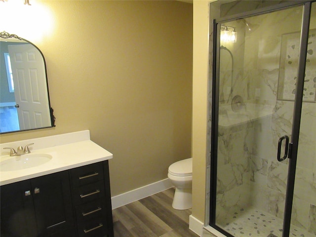 bathroom with a shower with door, hardwood / wood-style flooring, vanity, and toilet