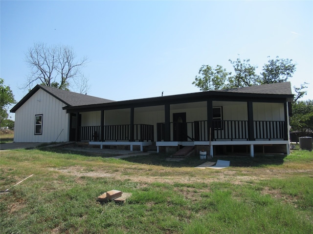 back of property with central AC and a yard