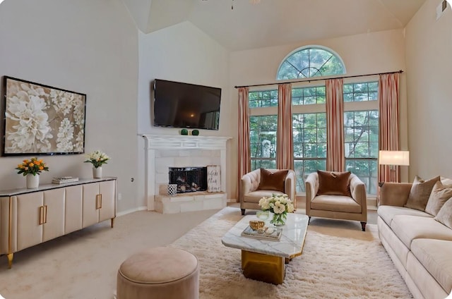 living area with baseboards, lofted ceiling, carpet, and a fireplace