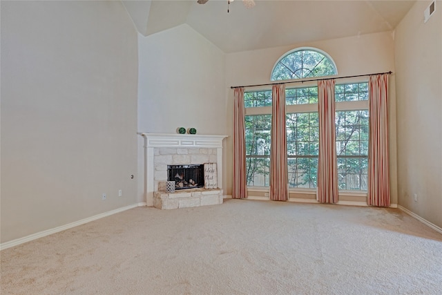 unfurnished living room with ceiling fan, carpet floors, a fireplace, and high vaulted ceiling