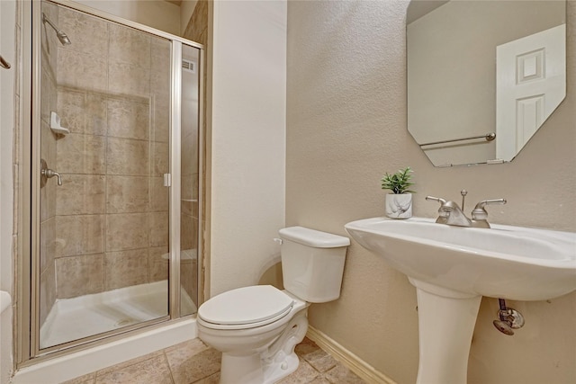 full bath with a shower stall, toilet, baseboards, and tile patterned floors