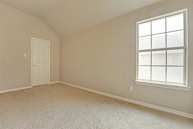 unfurnished room featuring vaulted ceiling, carpet, and baseboards