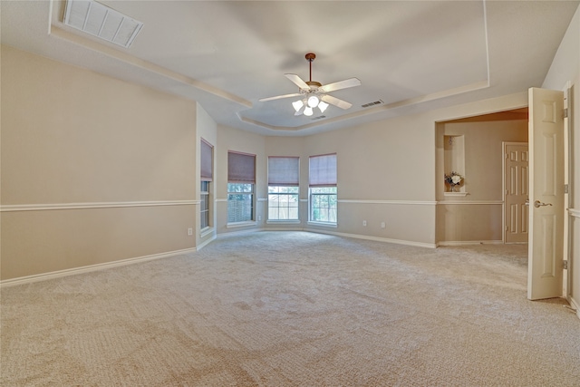 carpeted empty room featuring a tray ceiling and ceiling fan