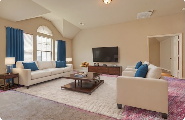 living room featuring visible vents, carpet, and vaulted ceiling