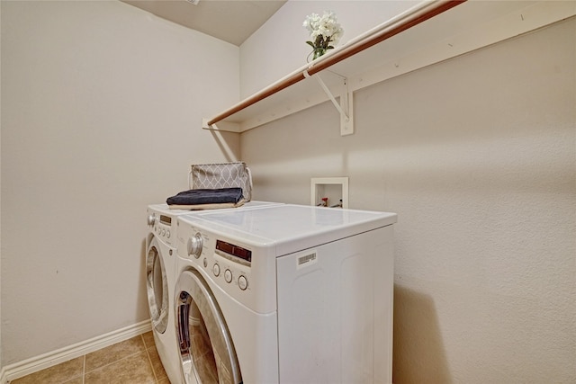 clothes washing area featuring light tile patterned floors, laundry area, baseboards, and separate washer and dryer