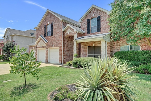 traditional home featuring brick siding, an attached garage, driveway, and a front yard