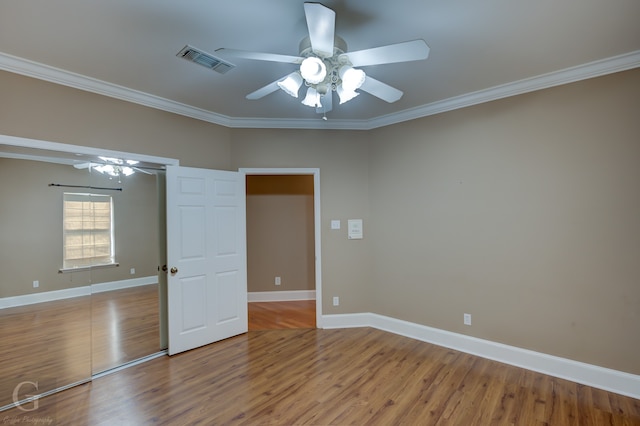 unfurnished bedroom featuring ceiling fan, wood-type flooring, and ornamental molding