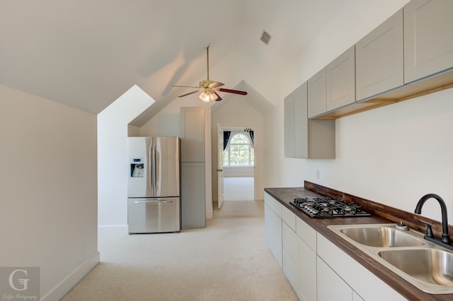 kitchen featuring light carpet, lofted ceiling, sink, ceiling fan, and stainless steel refrigerator with ice dispenser