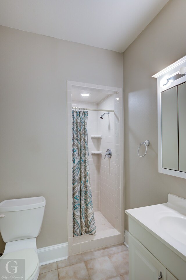 bathroom featuring tile patterned floors, vanity, toilet, and walk in shower