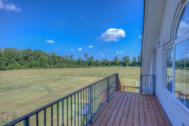 wooden terrace with a rural view and a yard