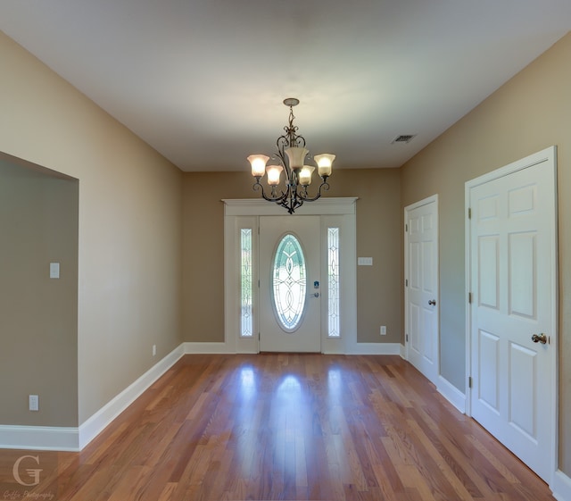 foyer with a notable chandelier and hardwood / wood-style floors