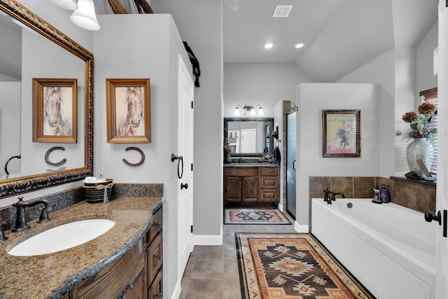 bathroom with tile patterned floors, vanity, lofted ceiling, and a bathtub