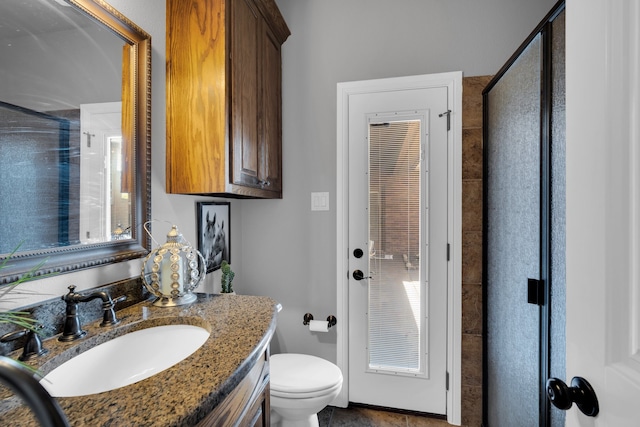 bathroom featuring a shower with shower door, vanity, tile patterned floors, and toilet