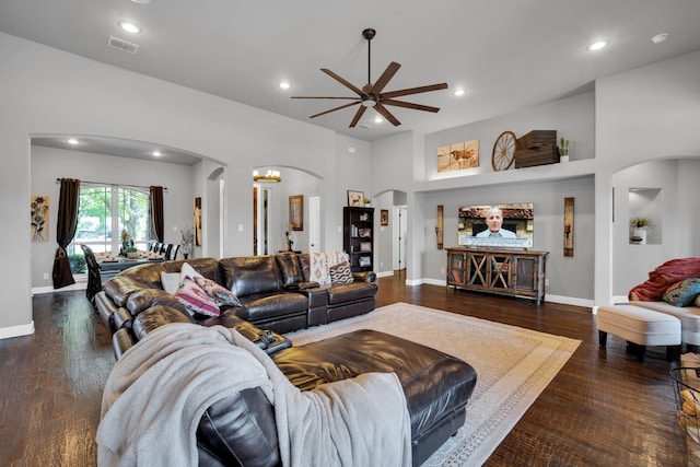 living room featuring ceiling fan, dark hardwood / wood-style floors, and a high ceiling