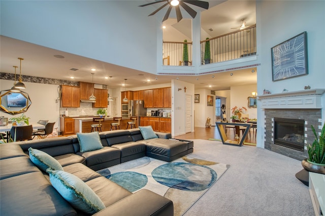 living room featuring ceiling fan, light wood-type flooring, and a towering ceiling