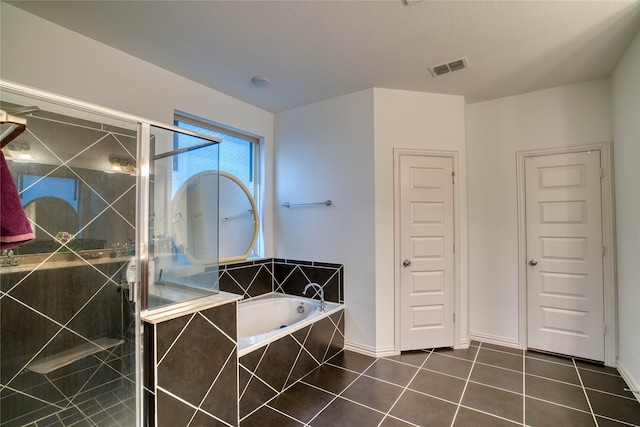 bathroom featuring a textured ceiling, independent shower and bath, and tile patterned flooring