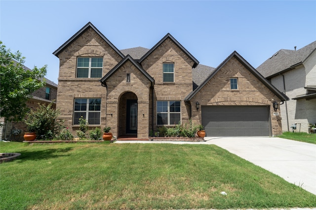 french country inspired facade featuring a front lawn and a garage