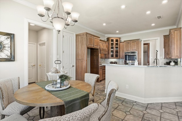 dining area with crown molding, sink, and a chandelier