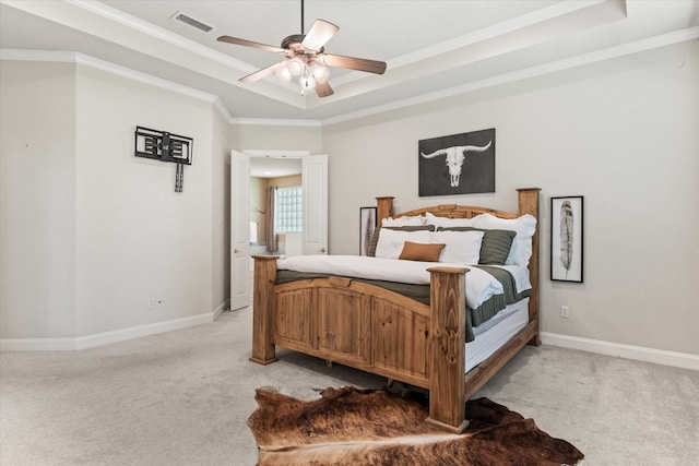 carpeted bedroom featuring crown molding, a raised ceiling, and ceiling fan