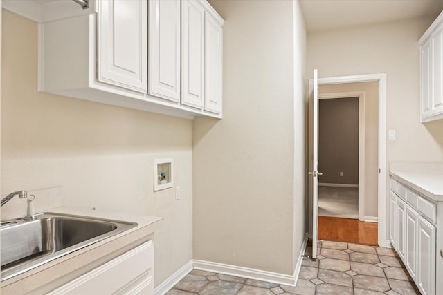 laundry area featuring sink, hookup for a washing machine, and cabinets