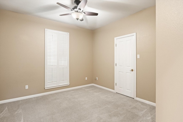 carpeted spare room with ceiling fan