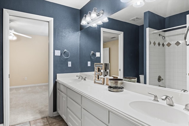 bathroom with a tile shower, vanity, tile patterned floors, and toilet