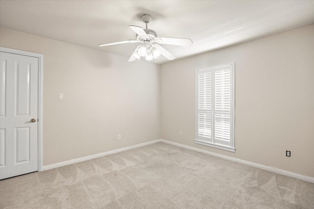 spare room featuring light carpet and ceiling fan