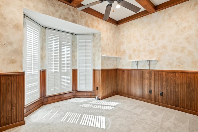 unfurnished room featuring coffered ceiling, light carpet, beam ceiling, and wood walls