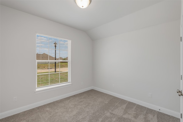 spare room featuring lofted ceiling and carpet