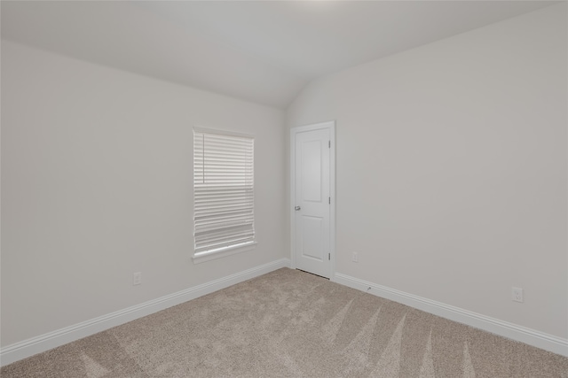 unfurnished room with carpet flooring and vaulted ceiling