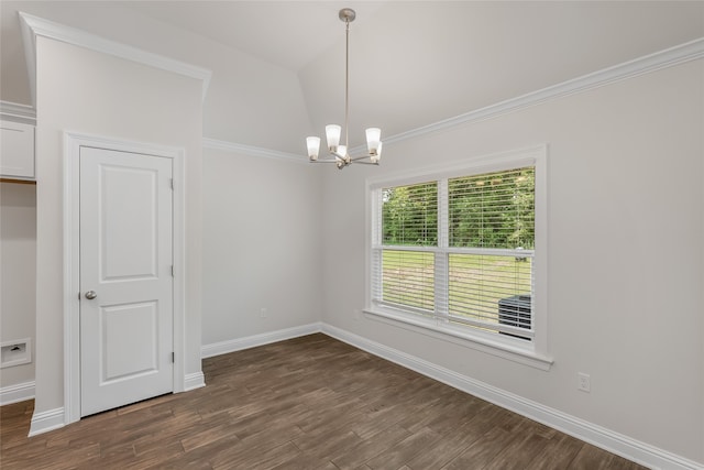 spare room featuring dark wood-type flooring, a chandelier, and crown molding