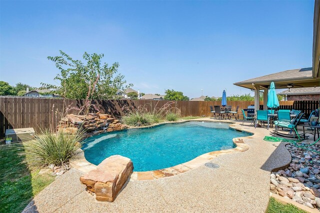 view of pool featuring ceiling fan, a patio area, pool water feature, and a lawn