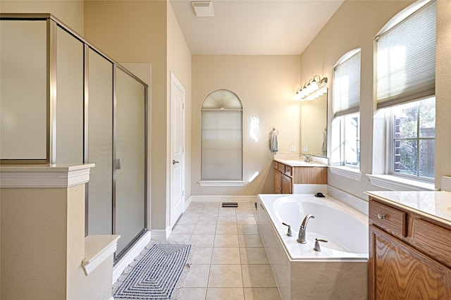 bathroom with tile patterned flooring, independent shower and bath, and vanity