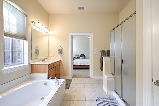 bathroom with tile patterned flooring, independent shower and bath, and vanity