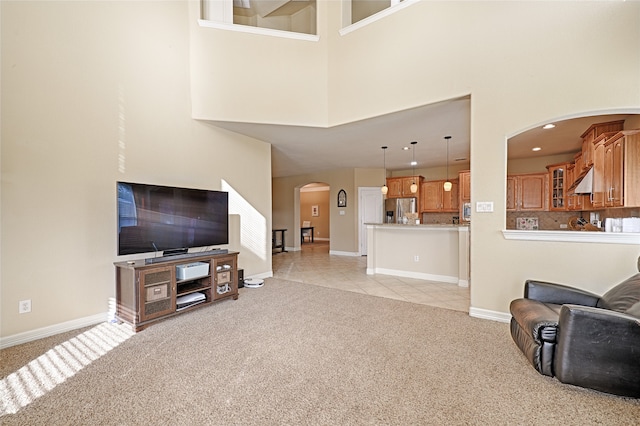 living room featuring light colored carpet and a towering ceiling