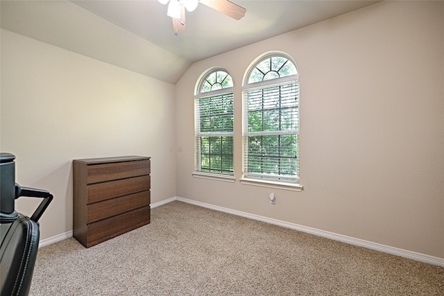 carpeted office space with ceiling fan and vaulted ceiling