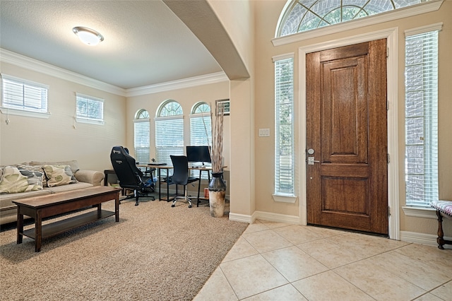 tiled entryway featuring crown molding and a healthy amount of sunlight