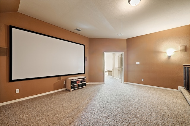 carpeted home theater room featuring vaulted ceiling