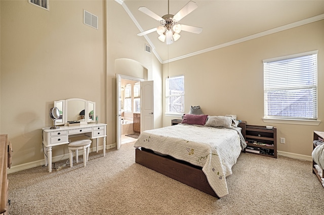 bedroom featuring ceiling fan, light colored carpet, high vaulted ceiling, ensuite bathroom, and crown molding