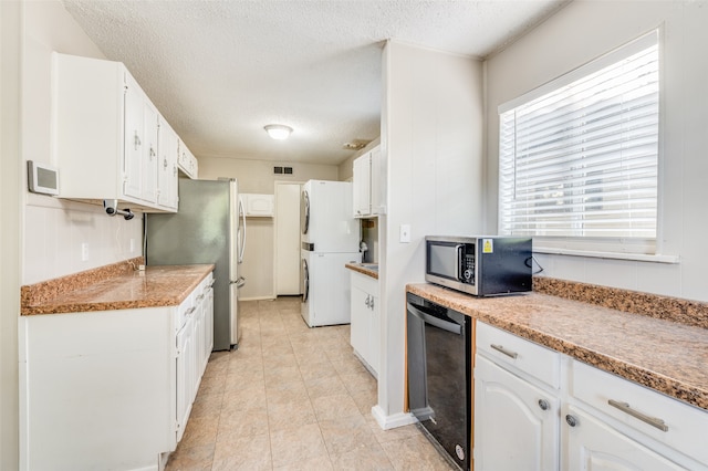 kitchen featuring appliances with stainless steel finishes, white cabinetry, light tile patterned floors, and a textured ceiling