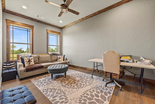 living room featuring wood finished floors, ceiling fan, a textured wall, and visible vents